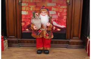 Standing Santa Claus in red plaid coat with burlap sack by a cozy fireplace