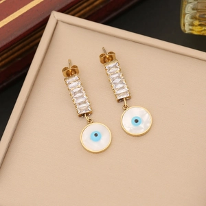 Golden evil eye earrings with rectangular zircons and white shell inlay on a display tray