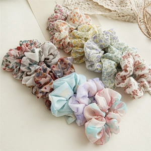 Detail of floral and tie-dye chiffon hair scrunchies in various soft pastel patterns