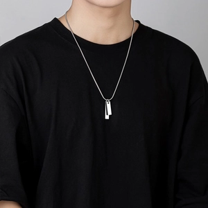 Close-up of a man wearing a silver titanium steel double rectangular tag pendant necklace