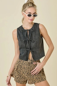Detail of dark grey washed denim vest with three black lace-up front ties and round neck