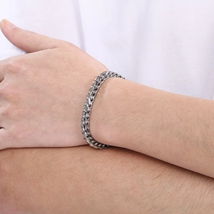 Detail of silver dragon bone chain bracelet made of stainless steel on a male wrist
