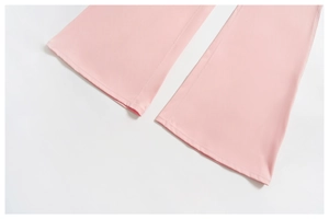 Detailed macro view of light pink flared yoga pants hem showing high-quality stitching