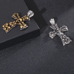 Detail of punk style skull cross pendants in vintage gold and silver stainless steel