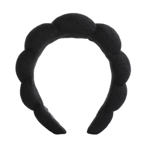 Detail view of thickened black sponge headband with unique wavy scalloped edge design