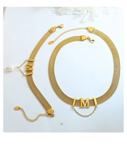 Detailed close-up of gold chain jewelry set with pearl charms and K18 hallmark logo