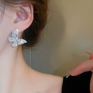 Sparkling zircon butterfly stud earrings in silver finish worn by a model for a luxury look