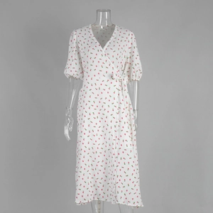 Détail d'une robe portefeuille blanche à fleurs avec manches bouffantes et lien