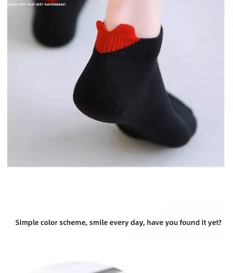 Close-up of black cotton ankle socks featuring a red wavy heart design on the heel