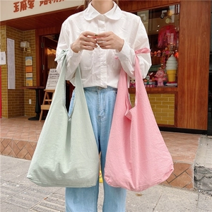 Detail of mint green and pink canvas tote bags with knotted handles in a Japanese style