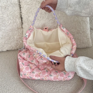 Détails de l'intérieur d'un sac matelassé rose à fleurs avec doublure et bandoulière