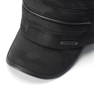 Close-up of black camo flat top cap showing fabric texture and metal brand plate