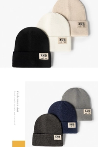 Détail de bonnets en tricot de six couleurs avec texture côtelée et écusson lettré