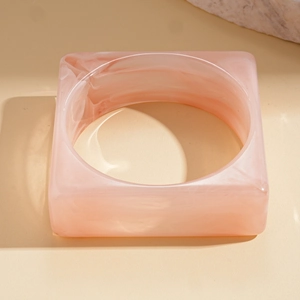 Detailed view of square chunky acrylic bangle with pink marble texture and smooth finish
