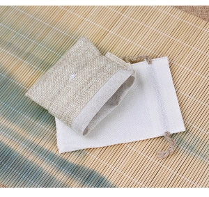 Flat lay of linen and cotton drawstring jewelry pouches on a bamboo mat background