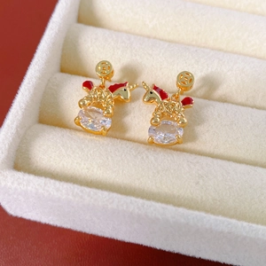 Detailed macro of 18k gold plated unicorn earrings with cubic zirconia and red enamel