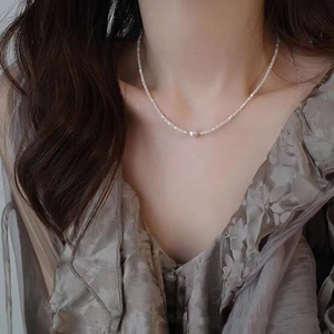 Elegant 14K gold pearl necklace with cat-eye stone beads worn on a model's neck