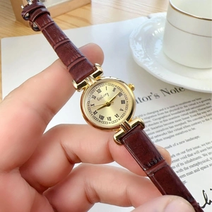 Vintage gold quartz women's watch with brown leather strap and beige Roman numeral dial
