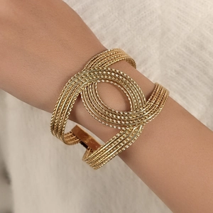 Vue détaillée d'un bracelet en fil doré torsadé à plusieurs couches sur le poignet
