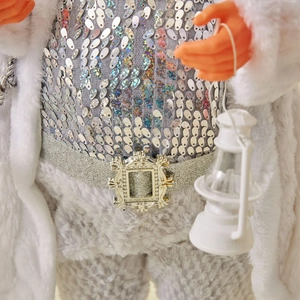 Silver sequin Santa Claus figurine in white faux fur coat holding a mini white lantern
