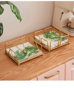 Modern gold metal napkin holder with wooden base and gravity arm for dining table