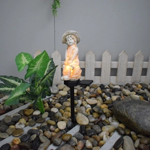 Solar powered angel garden statue lamp on pebbles with warm LED light effect
