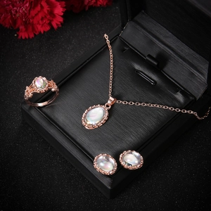 Elegant rose gold jewelry set with oval opal stones on a black display box