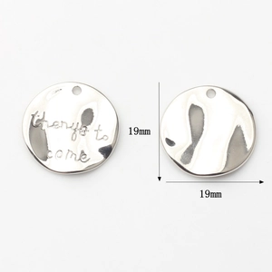 Macro detail of 19mm silver letter charm pendant with things to come engraving