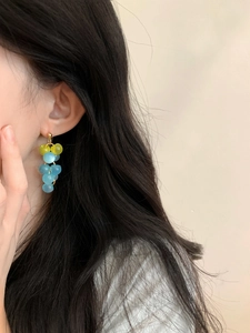 Détail des boucles d'oreilles grappe de raisin en résine vert-jaune et bleu