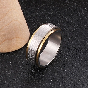 Macro view of two-tone spinner ring with engraved Spanish scripture on black leather