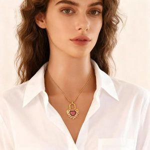 Close-up of elegant gold chain necklace with purple heart pendant on a female model