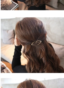 Detailed close-up of a golden hollow lip-shaped metal hair clip on model's hair