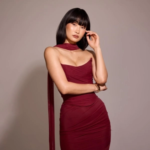 Detail of red bodycon dress featuring halter neck tie and elegant ruching texture