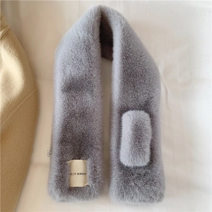 Detail showing plush grey faux rabbit fur scarf with a practical cross-insertion slot