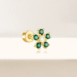 Macro shot of gold floral screw back stud earring with green and white crystals