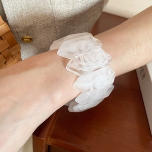 Close-up of irregular wavy acrylic bracelet with white marble texture on wrist