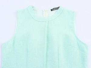 Detailed view of mint green tweed sleeveless top with round neck and hidden back zipper