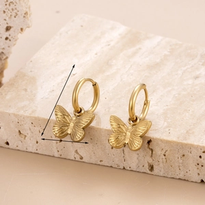 Elegant gold butterfly charm hoop earrings displayed on a minimalist beige stone background