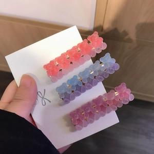 Three-piece set of gradient gummy bear hair clips with a matte resin finish on a card