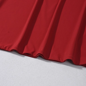 Vue détaillée du tissu en maille rouge foncé avec une texture côtelée et plis naturels