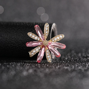 Detailed macro view of pink crystal flower brooch with gold plating and sparkling rhinestones