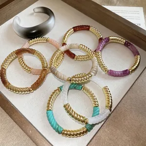 Set of acrylic threaded geometric bracelets and a translucent ring in a wooden tray