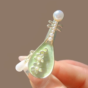 Pince à cheveux luth avec émail vert et perles blanches sur monture dorée