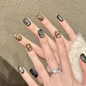 Elegant black and gold handmade press-on nails featuring pearls and golden star patterns