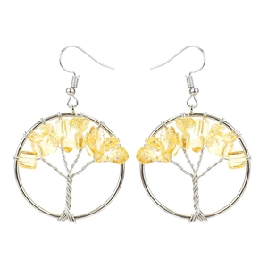 Macro detail of handmade wire-wrapped tree of life earrings with yellow crystals