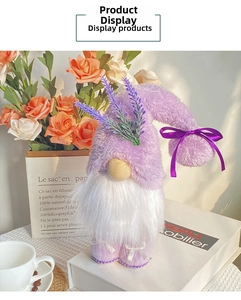 Detail of lavender gnome plush with purple bow and floral hat on a white book