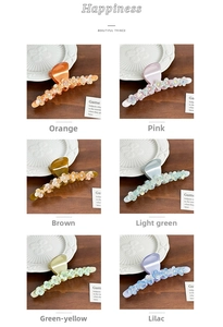 Detail view of large acetate flower claw clips in six vibrant colors with rhinestones