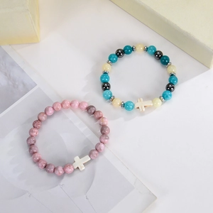 Vue détaillée de bracelets en perles de pierre naturelle de 8 mm avec croix blanches et cordon.
