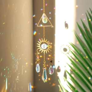 Detail of crystal sun catcher casting rainbow light spots onto wall with sun and stars