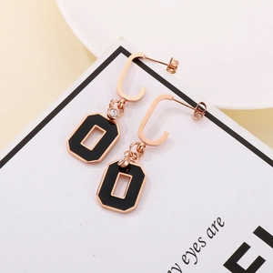 Detail of rose gold and black geometric earrings with crystal accents and C-shaped hook